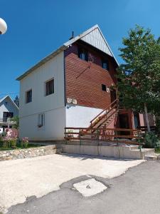 a large barn with a staircase on the side of it at Apartments Sipcic in Žabljak