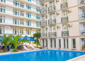 a hotel with a swimming pool in front of a building at Beach House in Batumi