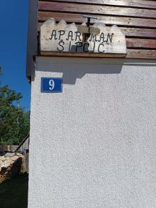 a sign on the side of a building at Apartments Sipcic in Žabljak