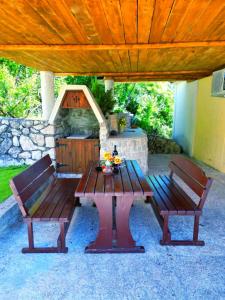 einen Picknicktisch und zwei Bänke unter einem Pavillon in der Unterkunft Dabanović House in Virpazar