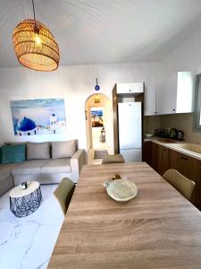 a kitchen and living room with a large wooden table at Santana Apartments in Perivolos