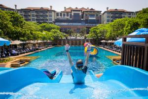 een vrouw in het water bij een zwembad in een resort bij The Capital Zimbali in Ballito