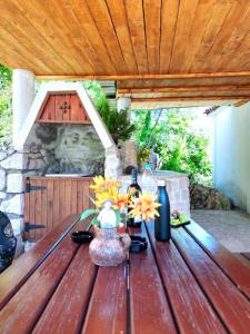 une table en bois avec un vase de fleurs. dans l'établissement Dabanović House, à Virpazar