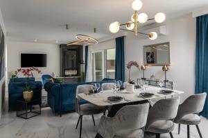 uma sala de jantar com uma mesa e um sofá azul em Luxury Wellness & Spa Villa Depaja em Zadar