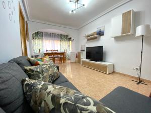 a living room with a couch and a television at Apartamento EL SOL DEL ZAPILLO in Almería