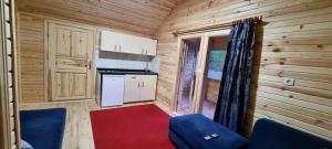 een kleine keuken in een blokhut met een blauwe stoel bij Aslan Apart Evleri in Uzungol