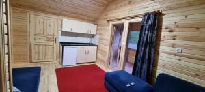 a small kitchen in a log cabin with a blue chair at Aslan Dağ Evleri in Uzungöl