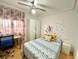- une chambre avec un lit, un bureau et un ventilateur de plafond dans l'établissement Apartamento EL SOL DEL ZAPILLO, à Almería