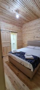 a bedroom with a bed in a wooden cabin at Aslan Dağ Evleri in Uzungöl