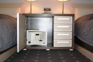 a microwave in a cabinet in a room with two beds at Garni Hotel Leopold I in Novi Sad