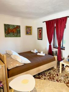 a bedroom with a bed with red curtains at Dabanović House in Virpazar