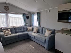 a living room with a blue couch with pillows at The fleet retreat in Weymouth