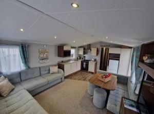 a living room with a couch and a table at The fleet retreat in Weymouth