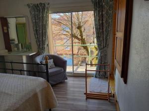 a bedroom with a bed and a large window at Comps sur Artuby, le tilleul et le four, Jabron in Comps-sur-Artuby