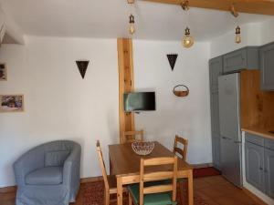 a dining room with a table and a chair and a kitchen at Comps sur Artuby, le tilleul et le four, Jabron in Comps-sur-Artuby