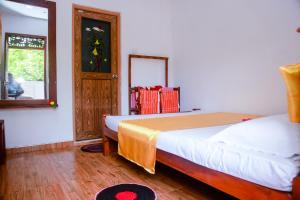a bedroom with two beds and a mirror and a window at Ranjith Guest in Mirissa