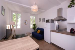 a kitchen and living room with a blue couch at Le Nostradamus - Magnifique appartement cours principal plein centre avec parking in Salon-de-Provence
