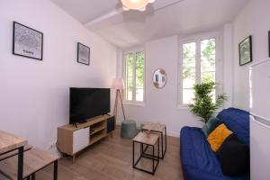 a living room with a blue couch and a tv at Le Nostradamus - Magnifique appartement cours principal plein centre avec parking in Salon-de-Provence