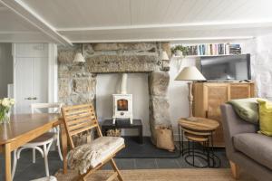 a living room with a table and a fireplace at Mariners Cottage in Mousehole
