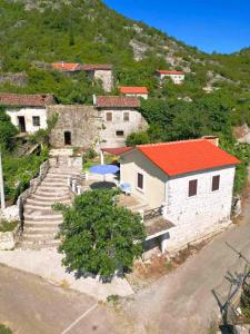 ein Gebäude mit einem roten Dach mit Treppen und einem Haus in der Unterkunft Dabanović House in Virpazar