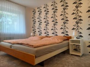 - une chambre avec un lit et un papier peint floral dans l'établissement 199 Fewo Havenbrücke, à Wilhelmshaven