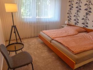 - une chambre avec un lit, une chaise et une lampe dans l'établissement 199 Fewo Havenbrücke, à Wilhelmshaven