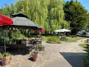 a gazebo with a table and benches and trees at The Royal Oak in Ashbourne