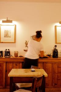 Una donna in piedi su un bancone in una cucina di Casa do Lado a Vila Nova de Milfontes