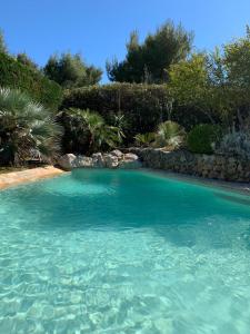 une grande piscine d'eau bleue dans une cour dans l'établissement Villa piscine privée, à Carry-le-Rouet