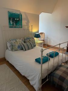 a bedroom with a large bed with white sheets and pillows at Bank Guest House in Coldstream