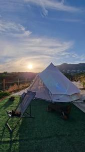 biały namiot i krzesło na trawie w obiekcie Glamping Finca el Olivo w mieście Mijas