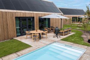 a backyard with a pool and a table and an umbrella at Resort de Weelderik in Hengelo