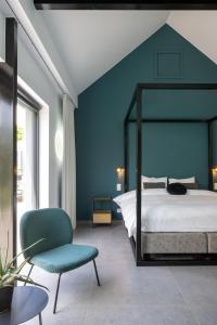 - une chambre avec un lit et un mur bleu dans l'établissement B&B Tannerie, à Balen