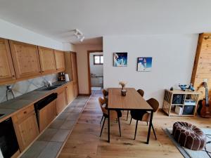 eine Küche mit einem Holztisch und einem Esszimmer in der Unterkunft Appartement de charme - Idéal pour un couple in Nendaz
