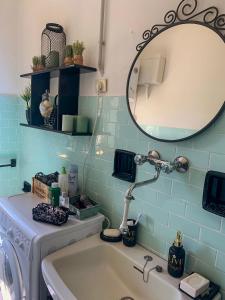 een badkamer met een wastafel, een spiegel en een wasmachine bij Villa Magnolia in Crosano