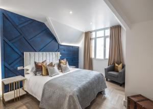 um quarto com uma cama grande e uma parede azul em The Pocklington - The Magistrates Suite em Leicester