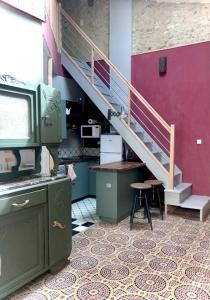 een kamer met een trap, een tv en een kruk bij Grand studio indépendant in Paulhan