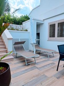 een patio met 2 stoelen en een tafel bij Pescoluse Apartments in Marina di Pescoluse