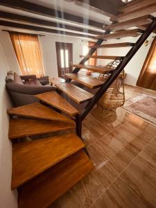 a living room with wooden stairs and a couch at Cozy Weekend House Zaid in Bihać