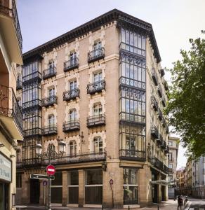 a large brick building with balconies on a street at Catalonia El Pilar in Zaragoza