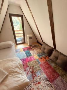 a attic room with a bed and a rug at Cozy Weekend House Zaid in Bihać