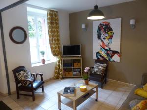 sala de estar con sofá y TV en Chez Jean - Newly renovated air-conditioned flat at the foot of the ramparts, 4 people, en Carcassonne