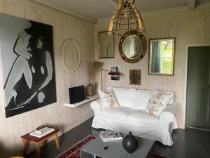 Grootschermer的住宿－Ingeborgh Art Gastenverblijf，客厅配有白色的沙发和桌子