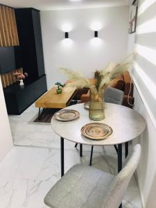 a dining room table with a vase on it at Urban Chic Studio in Niš