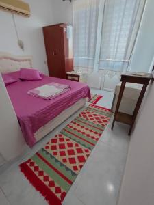 een slaapkamer met een bed en een tapijt op de vloer bij ATHERİNA BUTİK OTEL in Kas
