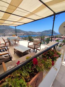 een balkon met tafels en stoelen en uitzicht op de oceaan bij ATHERİNA BUTİK OTEL in Kas