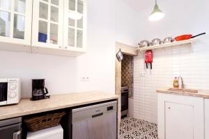 uma cozinha com armários brancos e uma bancada em Historical Apartment em Lisboa