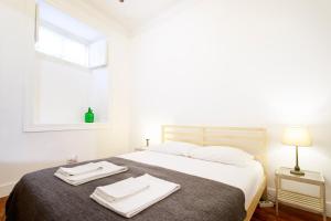 um quarto com uma cama com duas toalhas em Historical Apartment em Lisboa