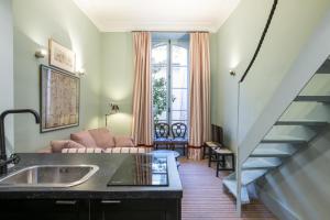 Pick A Flat's Apartment in Saint-Germain des Près - Rue Paul Louis Courier في باريس: غرفة معيشة مع حوض ودرج