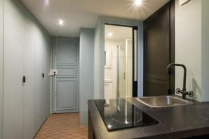 Pick A Flat's Apartment in Saint-Germain des Près - Rue Paul Louis Courier في باريس: حمام مع حوض ومرآة